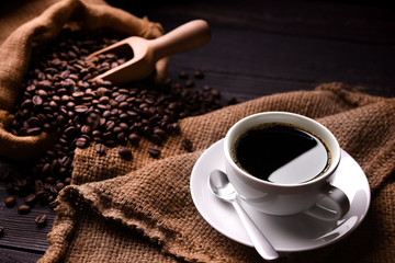 Leinwandbilder Kaffee Bar Kaffeebohnen im Jutesack mit Tasse  © amenic181