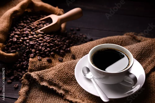 Obraz Cup of coffee and coffee beans in burlap sack on old wooden background