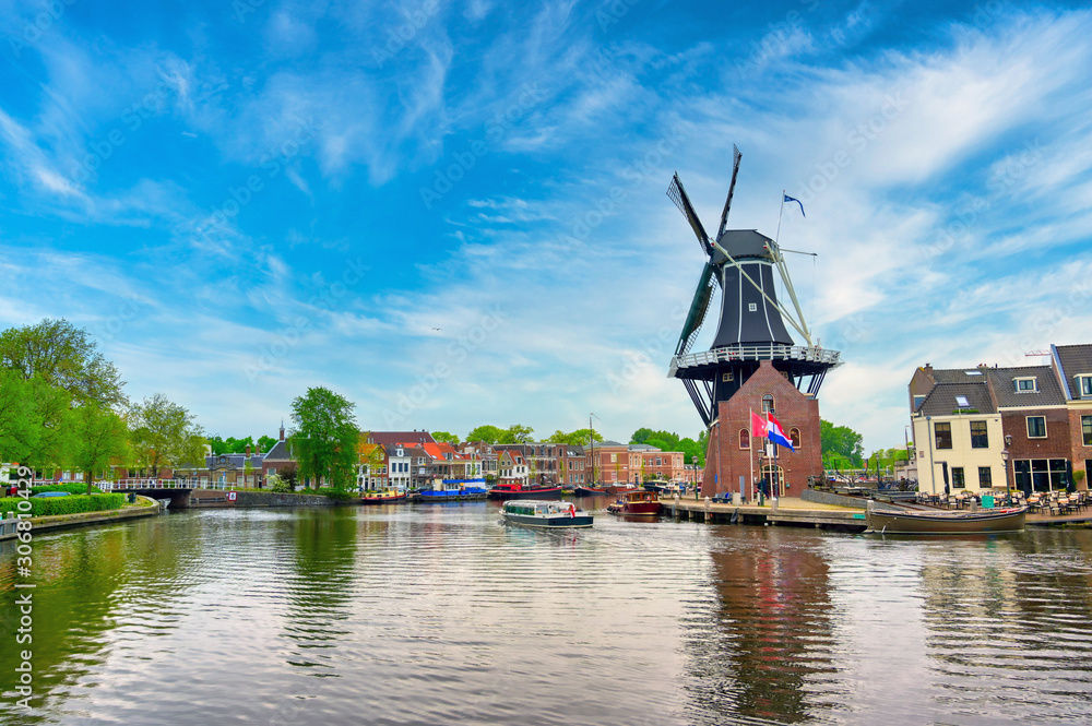 A windmill along the canals in Haarlem, Netherlands on a clear day.