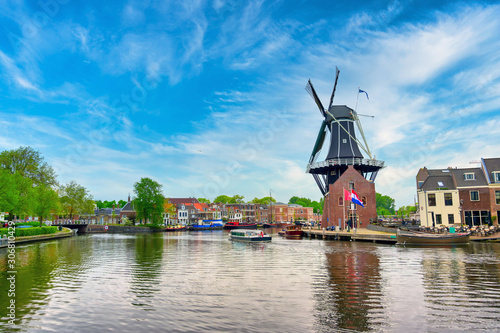 Obraz na płótnie A windmill along the canals in Haarlem, Netherlands on a clear day. w salonie