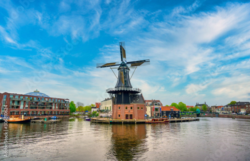 A windmill along the canals in Haarlem, Netherlands on a clear day.