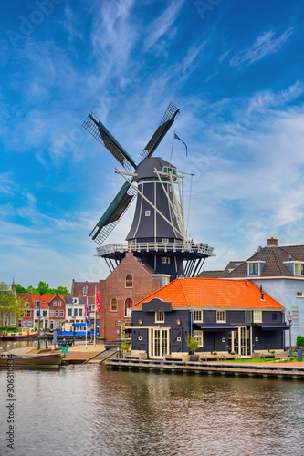 A windmill along the canals in Haarlem, Netherlands on a clear day.