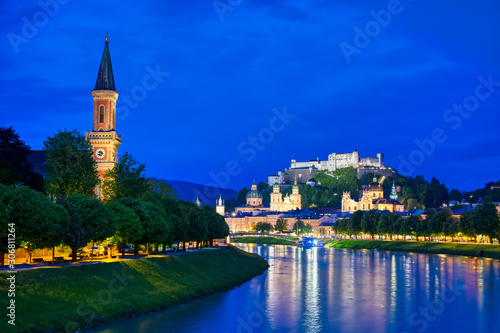 A view of Salzburg, Austria along the Salzach River at night.
