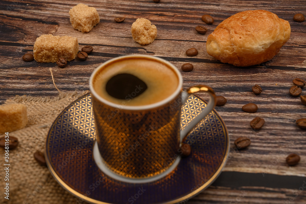 Coffee Cup, croissants, brown sugar and coffee beans on wooden background. Close up. Coffee Cup, croissants, brown sugar and coffee beans on wooden background. Close up.