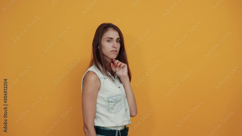 Caucasian young woman in blue denim shirt keeping palms directly, NO gesture, disappointed isolated on orange background in studio. People sincere emotions, lifestyle concept. Caucasian young woman in blue denim shirt keeping palms directly, NO gesture, disappointed isolated on orange background in studio. People sincere emotions, lifestyle concept.