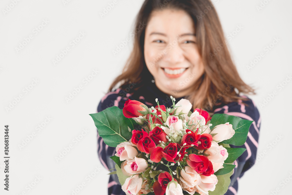 Asian smiling woman on gray studio shot with red rose flower. Asian smiling woman on gray studio shot with red rose flower.