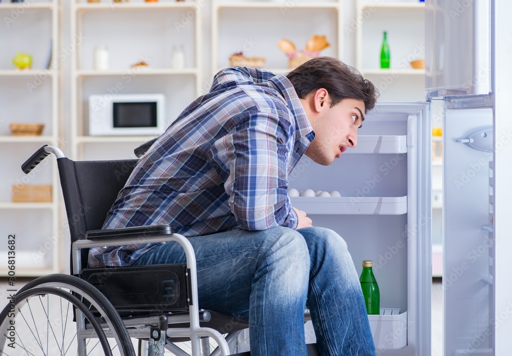 Young disabled injured man opening the fridge door