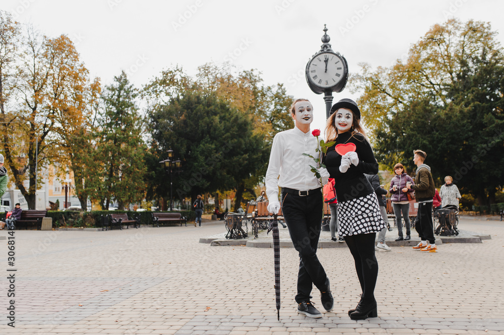 A couple of merry mimes. He hurries on a date.