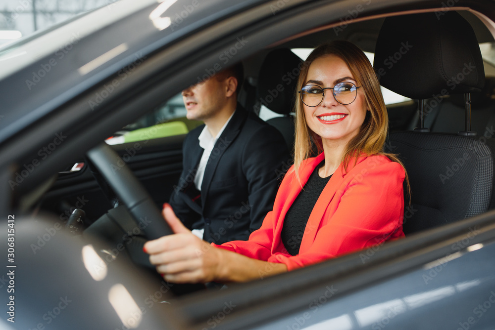 business woman buys a car at a car dealership. Concept of happy business people