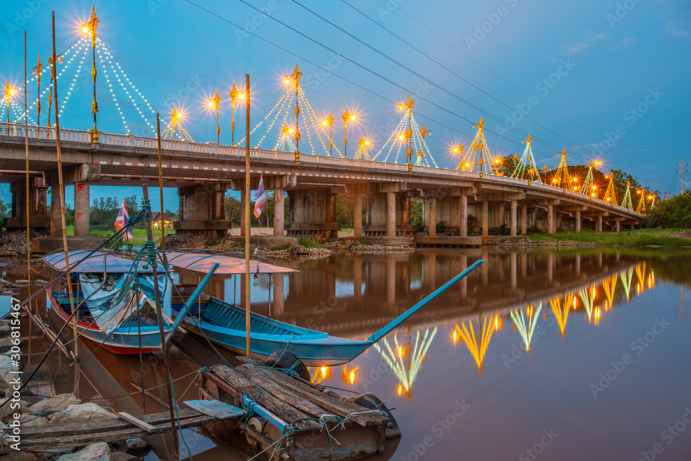 Twilight view of long tail boat and Mae Fah Luang bridge the large bridge  builed for crossing Kok river the river that runs through the city of  Chiang Rai province, Thailand. Stock