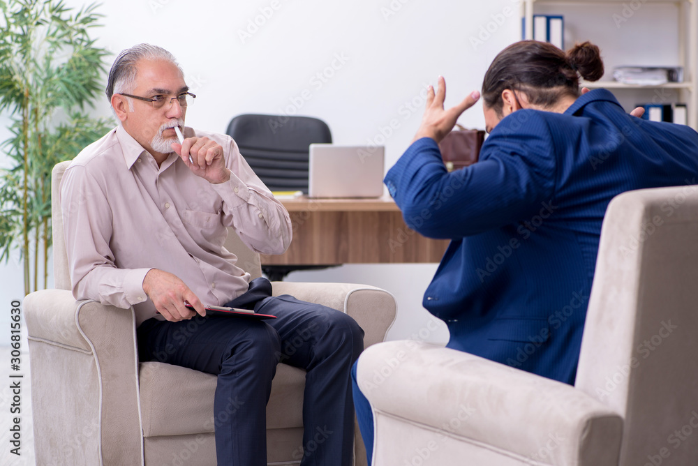 Young man visiting old male doctor psychologist