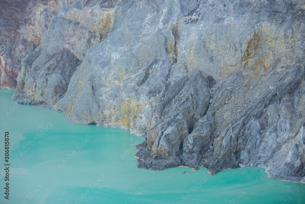 Acid lake view from crater of Kawah Ijen volcano in Java island, Indonesia at dawn.