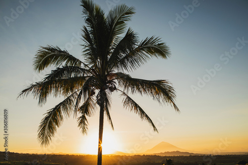 Tropical sunset with palm view and mountains on background. Vacations in Asia, empty place for sign, logo or text. Harmony in nature.