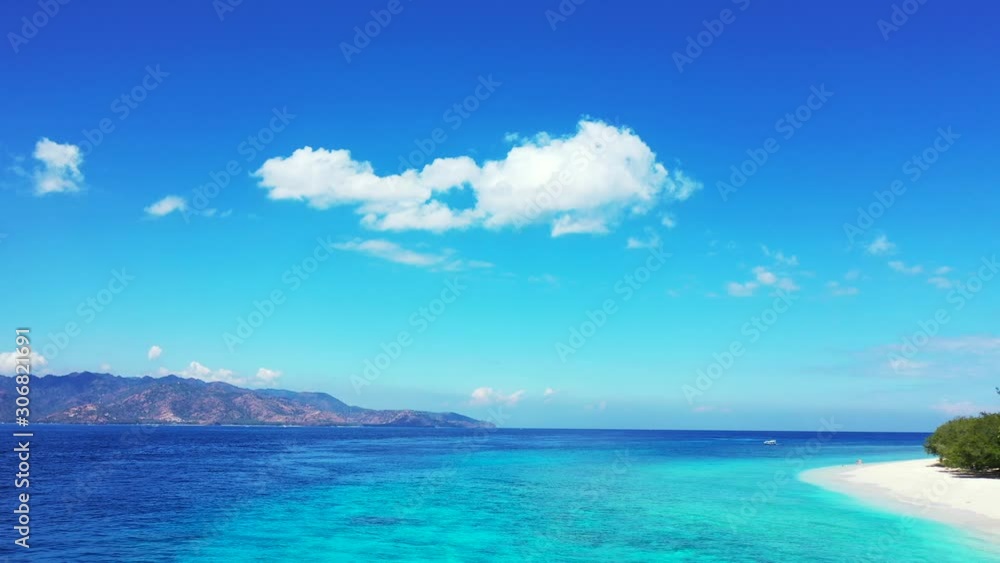 Vivid colors of amazing seascape with bright blue sky with static clouds hanging over blue turquoise sea between two tropical islands in Indonesia Vivid colors of amazing seascape with bright blue sky with static clouds hanging over blue turquoise sea between two tropical islands in Indonesia