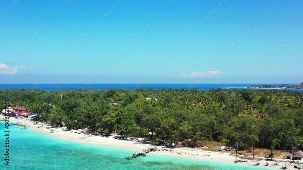Tropical island with lush vegetation and palm trees forest by the blue turquoise sea washing white sandy beach, perfect location for vacation in Indonesia Tropical island with lush vegetation and palm trees forest by the blue turquoise sea washing white sandy beach, perfect location for vacation in Indonesia