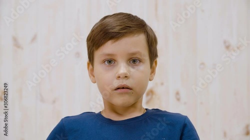Portrait afraid with fright looking to camera in light studio. Close up scared boy face. Surprased teenager on light background. Expression facial children emotions