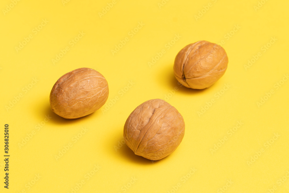 Delicious walnuts on bright yellow background. Delicious walnuts on bright yellow background.