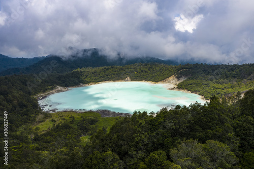 View from above, stunning aerial view of the Talaga Bodas Lake surrounded by a tropical forest. Talaga Bodas crater is one of the tourist attractions in the Garut Regency in the West Java, Indonesia. photo