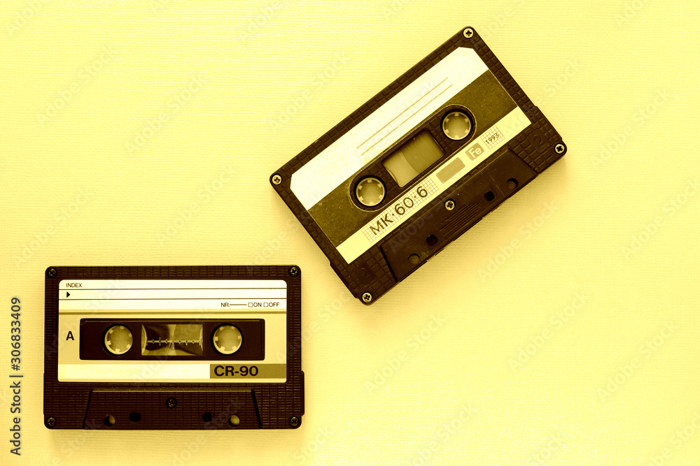 Two audio tape cassettes, top view. Old technology concept. Yellow color toned