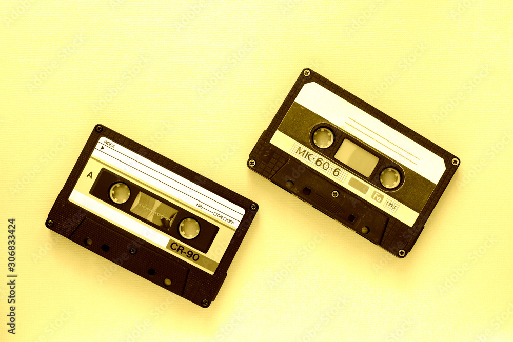 Obraz premium Two audio tape cassettes, top view. Old technology concept. Yellow color toned