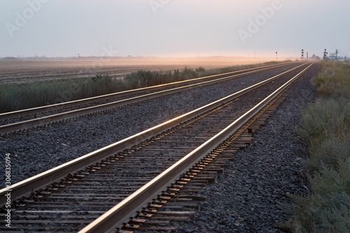 Empty Pair of Railroad Tracks at Sunrise on the Prairie