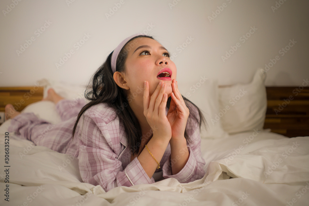 lifestyle portrait of young beautiful and sweet Asian Chinese woman in bed feeling happy and relaxed wearing cute pajamas enjoying lazy Sunday morning at home lifestyle portrait of young beautiful and sweet Asian Chinese woman in bed feeling happy and relaxed wearing cute pajamas enjoying lazy Sunday morning at home
