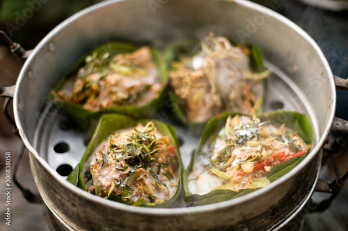 Thai food wrapped in banana leaves on a charcoal stove