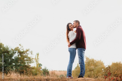 Beautiful young couple walking in autumn park. © Serhii