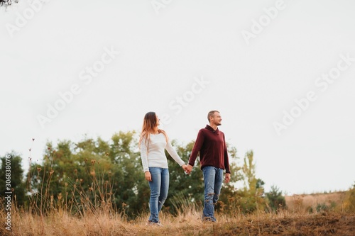 low contrast image of a happy romantic young couple spending time outdoor in the autumn park
