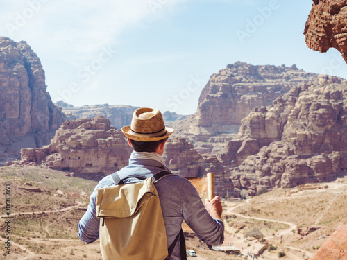Handsome man, exploring the sights of the ancient, fabulous city of Petra in Jordan. Colorful photos. Concept of leisure, vacation and travel