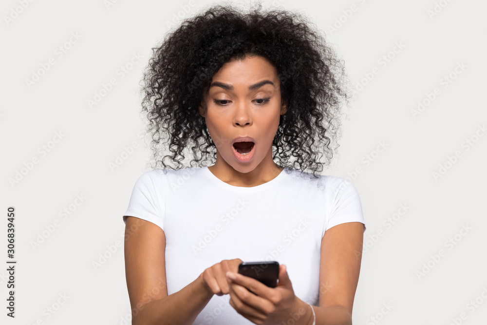 Shocked African American woman with open mouth using cellphone Shocked African American woman with open mouth using cellphone