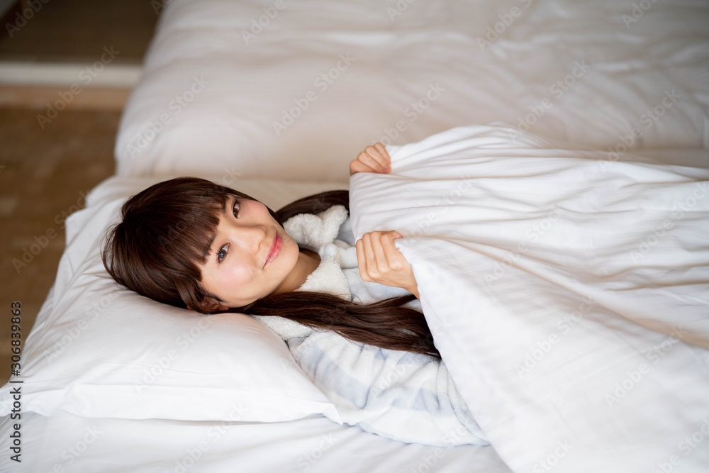 ベッドで微笑む女性 ベッドで微笑む女性