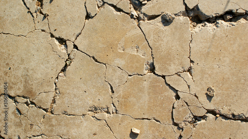 texture of the old crushed sand-colored cement slab with cracks and holes photo
