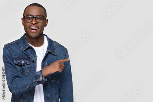 Happy African American man pointing finger at copy space
