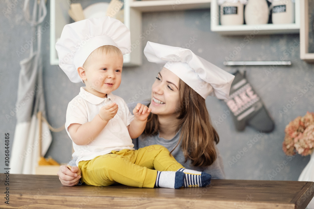 mother and child on kitchen, white hats of chef, relationships of mother and son mother and child on kitchen, white hats of chef, relationships of mother and son