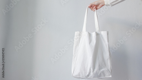 Woman holding canvas tote bag on white background. Reusable Eco bag. Eco friendly concept.