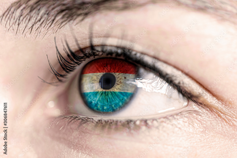 Obraz premium Flag of luxembourg reflects in woman green eye - close-up view - election, sport, hope, young, generation 