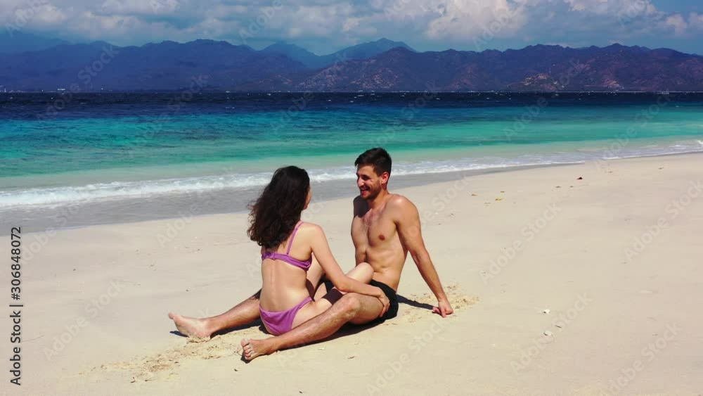 summer romance concept. Young couple sitting on the white sand beach and cuddling, Caribbean summer romance concept. Young couple sitting on the white sand beach and cuddling, Caribbean
