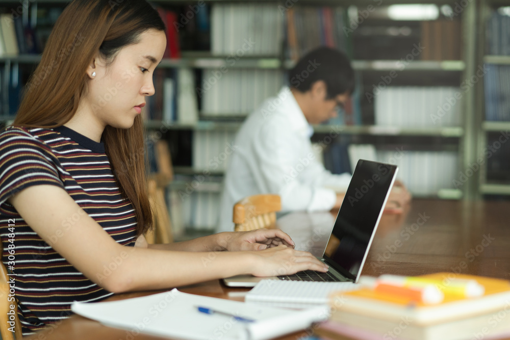 female asian student studying and reading book in library female asian student studying and reading book in library