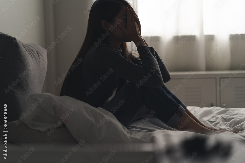 Suffer from depression , mental health problem. asian young woman sitting on the bed feeling depressed. - obrazy, fototapety, plakaty 