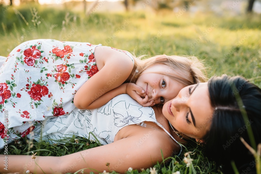 Mother and daughter having fun in the park. Happiness and harmony in family life. Beauty nature scene with family outdoor lifestyle. Mother and daughter having fun in the park. Happiness and harmony in family life. Beauty nature scene with family outdoor lifestyle.