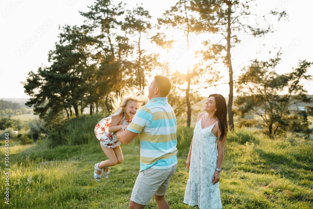 Happy family of three persons walking the grass in the park. Happy family of three persons walking the grass in the park.