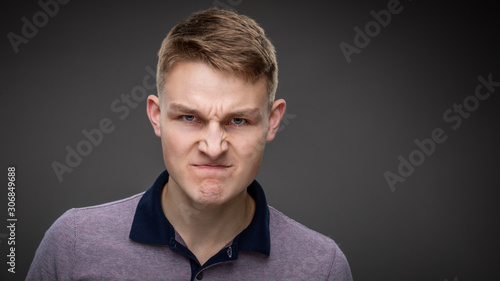 An angry young man ready to fight isolated against a grey background