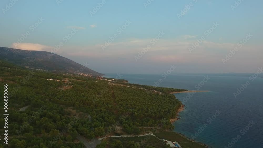 Scenic coastal landscape of Croatia at sunset with beautiful colors in the sky. Wide aerial view from drone backing reveals the shoreline and terrain of the island. Scenic coastal landscape of Croatia at sunset with beautiful colors in the sky. Wide aerial view from drone backing reveals the shoreline and terrain of the island.
