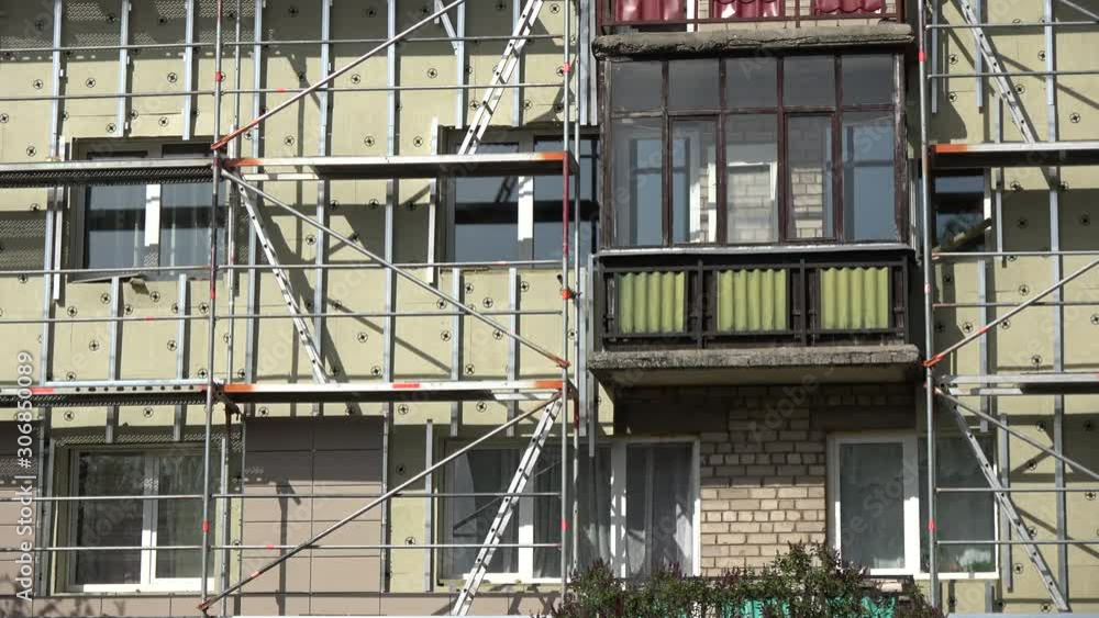 Old flat house renovation and insulation work place with scaffolding, zoom in Old flat house renovation and insulation work place with scaffolding, zoom in
