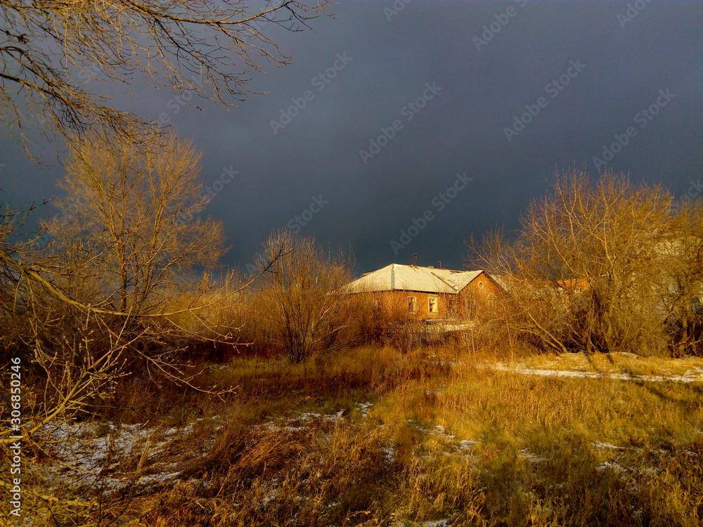 Village house on a background of snow clouds. The concept of suburban travel and outdoor recreation.