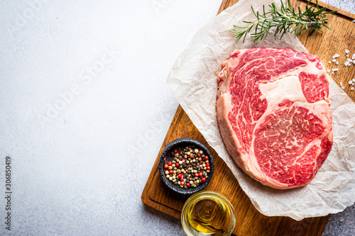 Bild auf Leinwand Raw fresh meat Ribeye Steak and seasonings on light background, top view with co