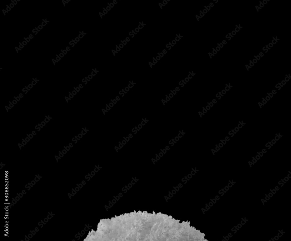 pile of fluffy white snow isolated on a black background.