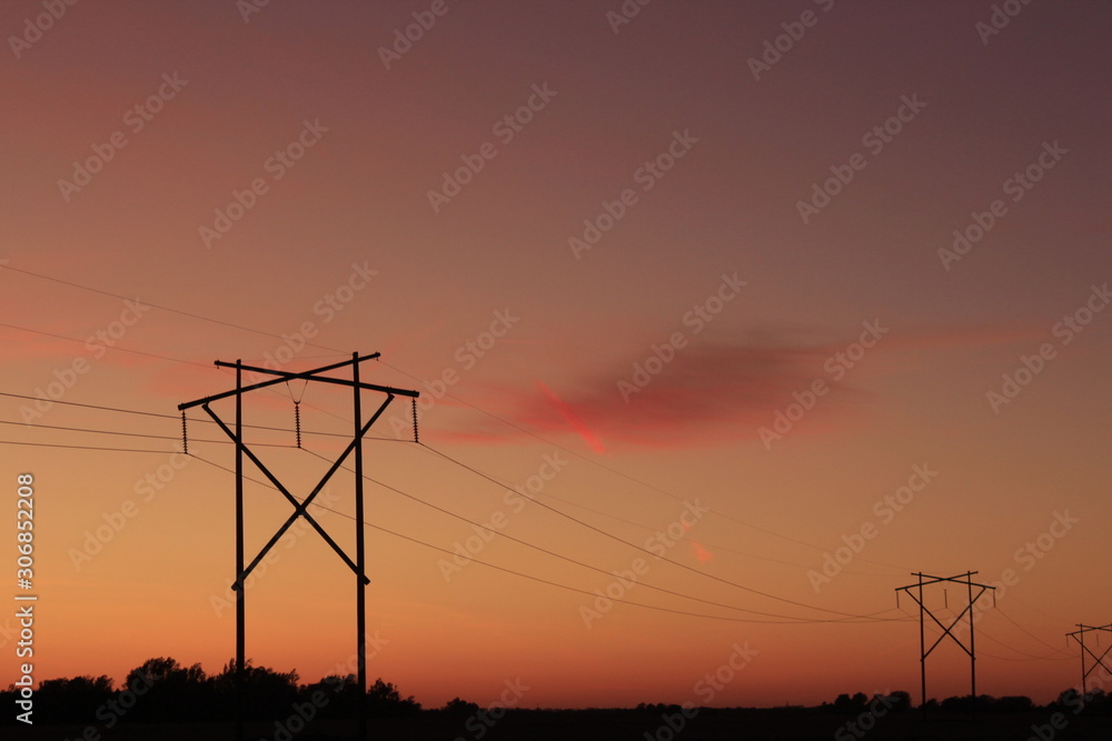 electricity pylons at sunset with a colorful Country sky.