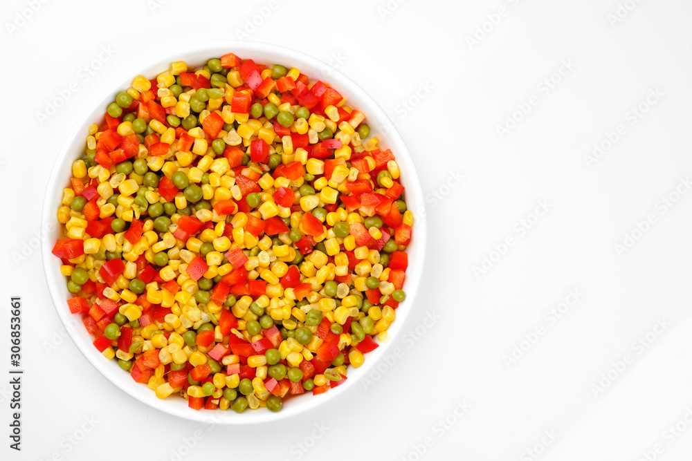 a mix of chopped vegetables paprika, corn, peas in white plate top view a mix of chopped vegetables paprika, corn, peas in white plate top view